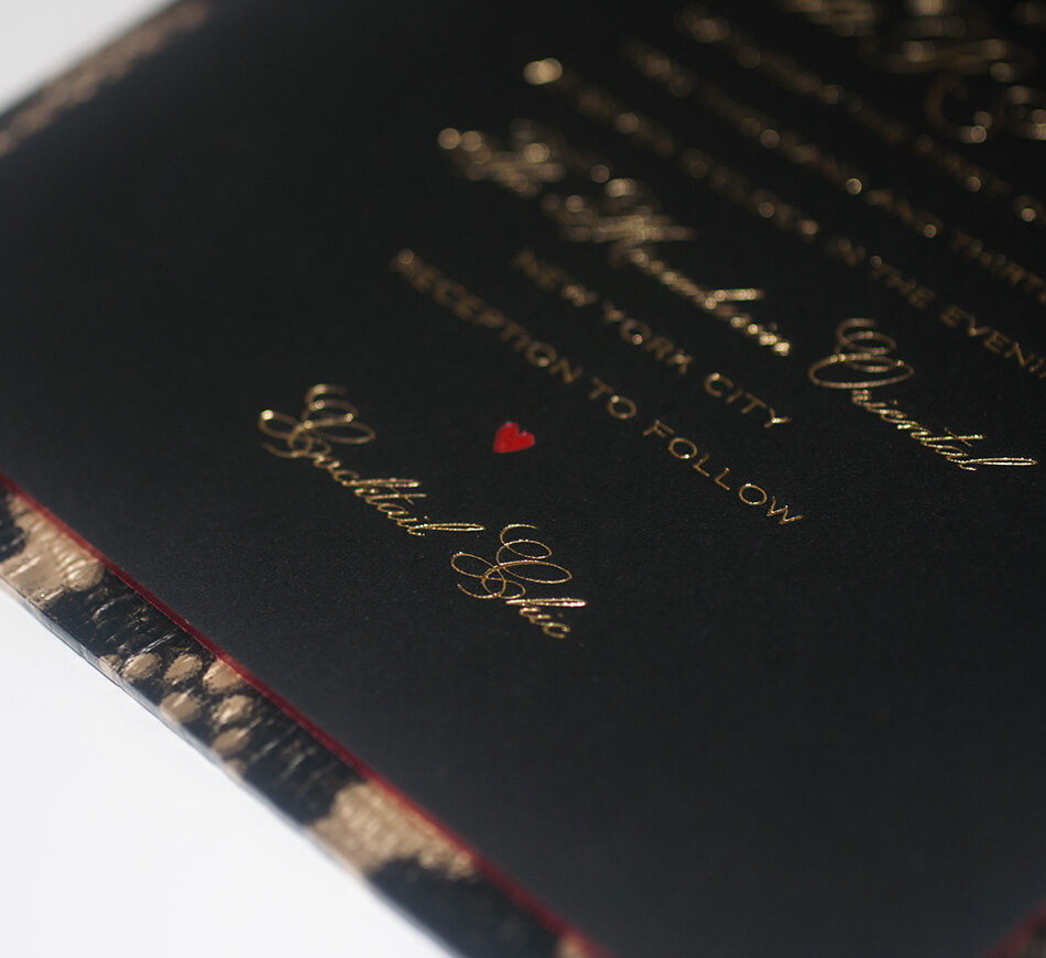 Gold calligraphy lettering on a black invite