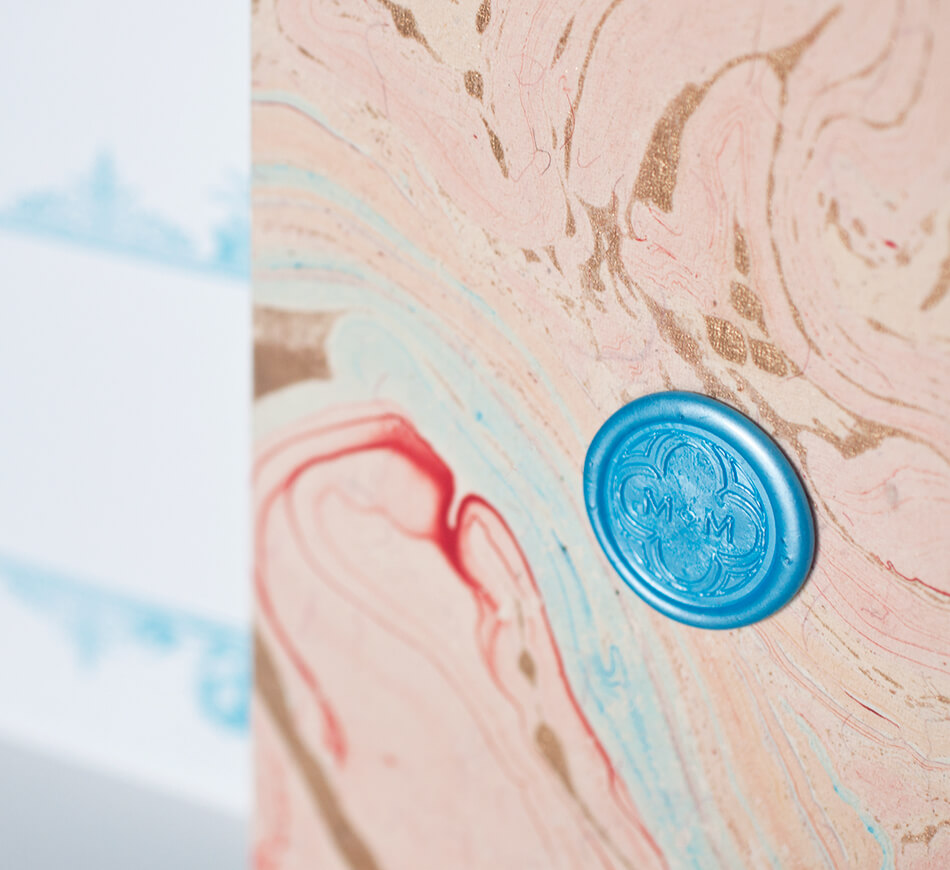 Blue wax seal on hand marbled paper