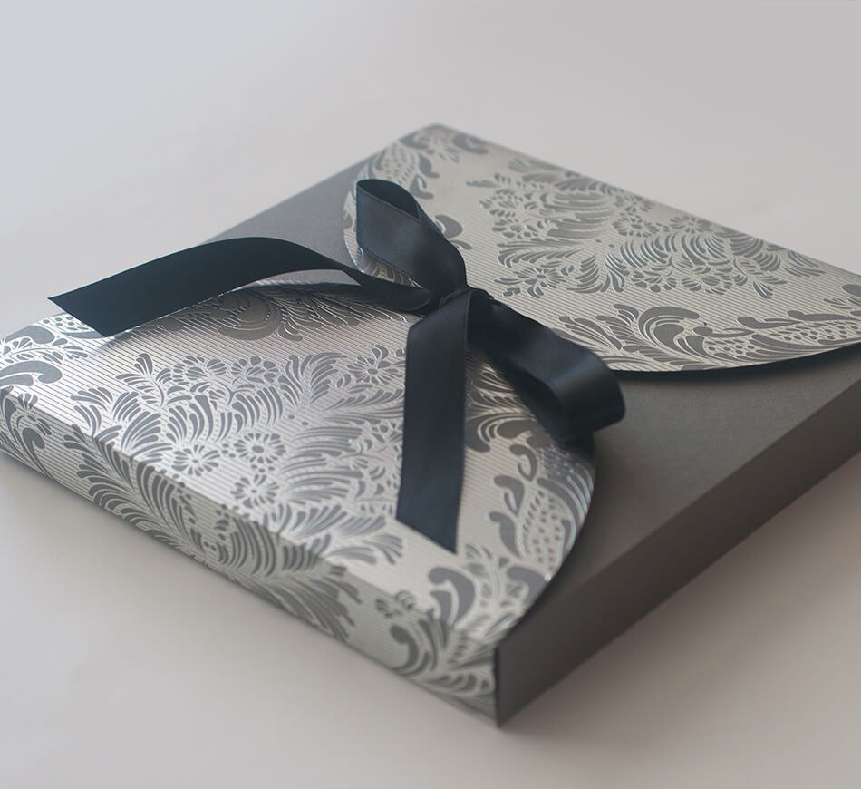 Silver foil stamped box with a ribbon