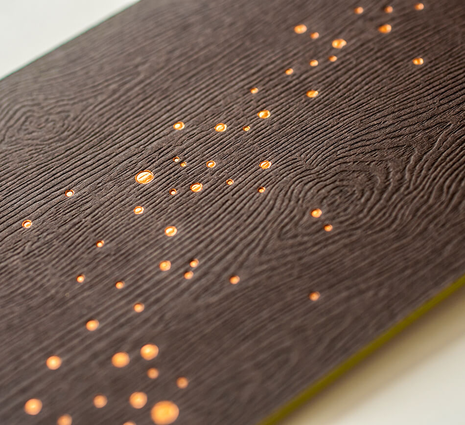 Copper foil fireflies on wood embossed paper