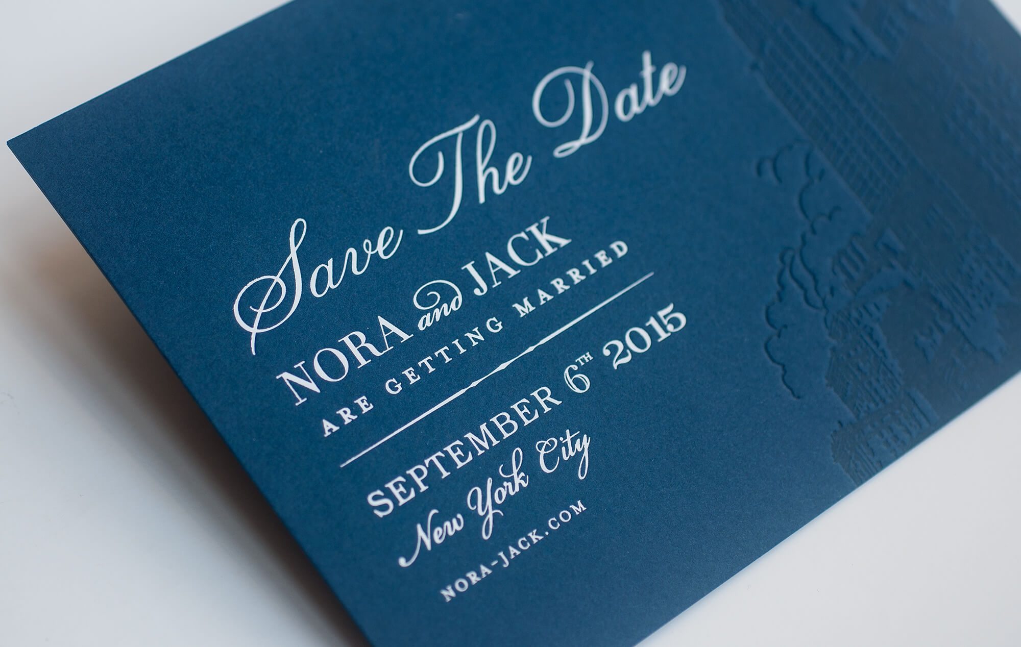 White foil on a navy blue save the date