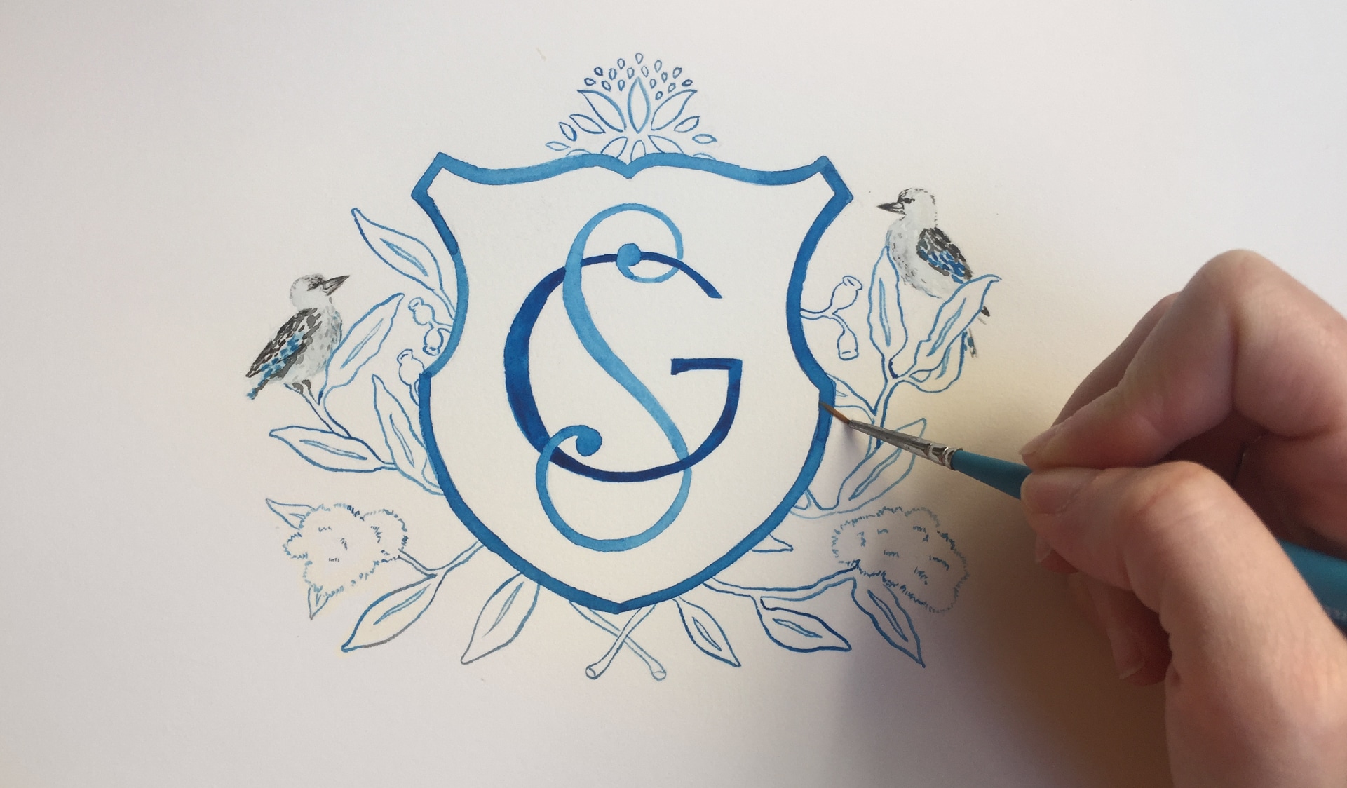 Watercolor painting of crest and monogram
