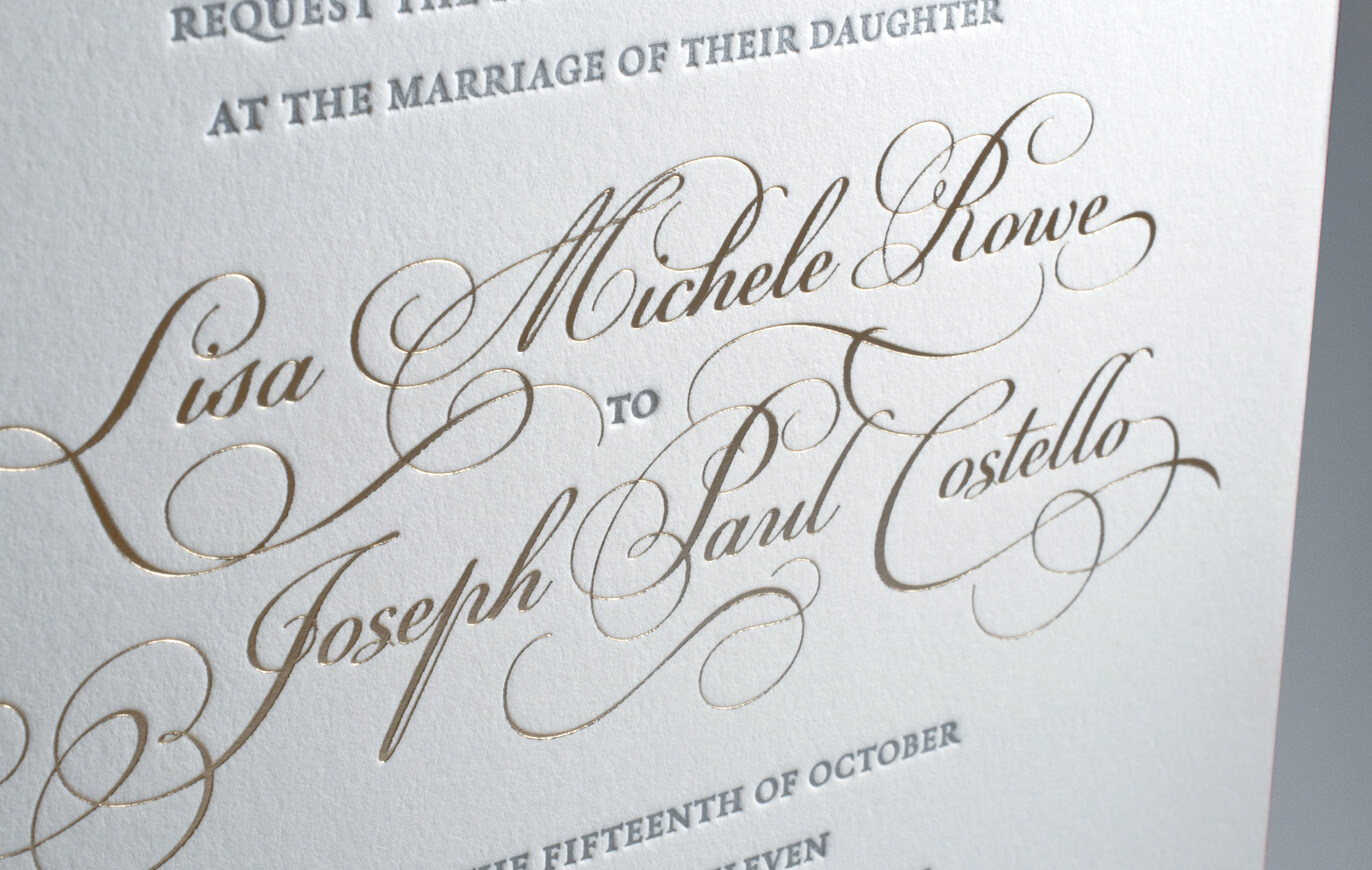 Gold calligraphy lettering on a wedding invitation