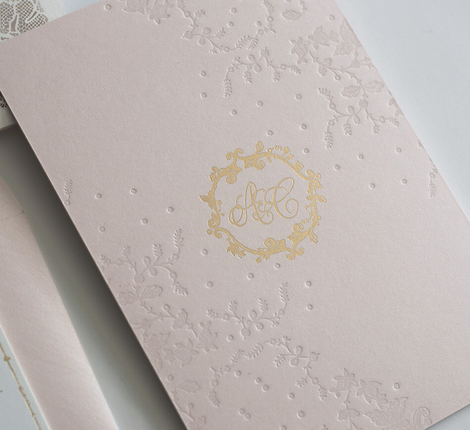 Gold monogram on blush invitation backer