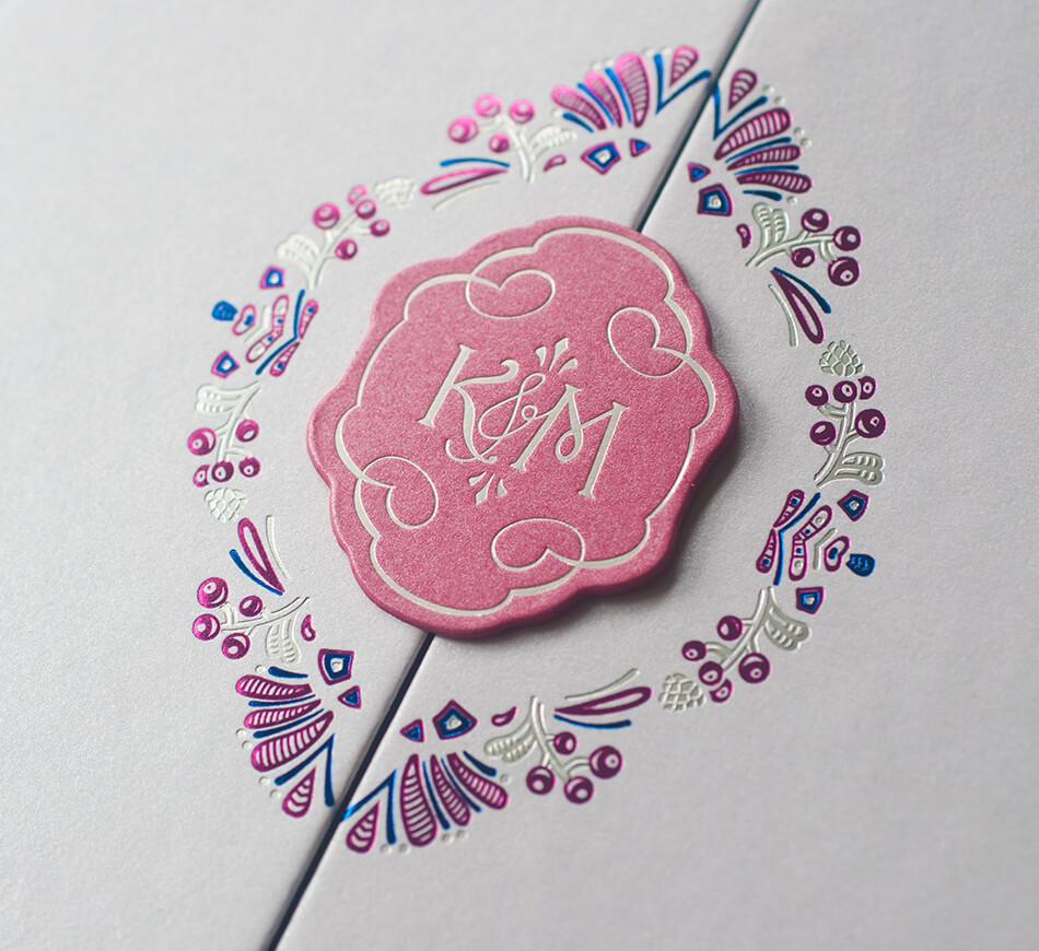 Florals and berries around a pink monogram cameo