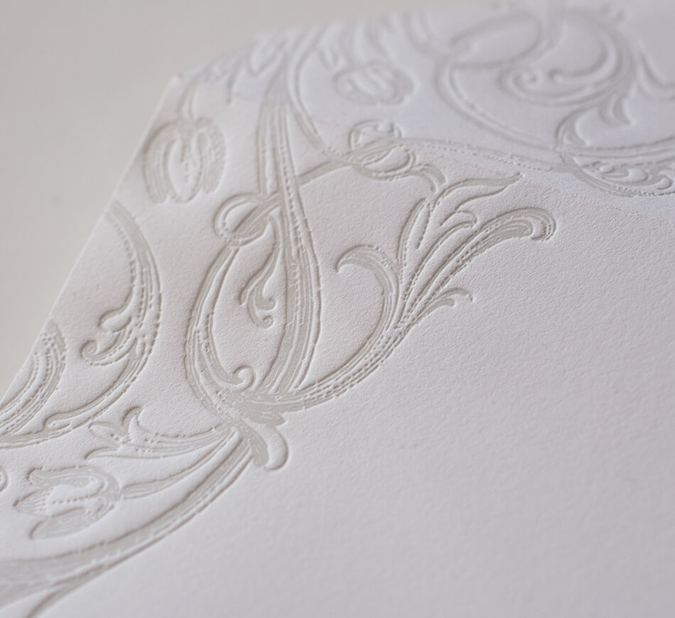 Grey letterpress scrollwork on an envelope