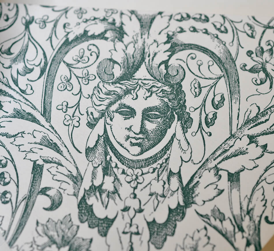 Ornate engraved envelope detail in forest green