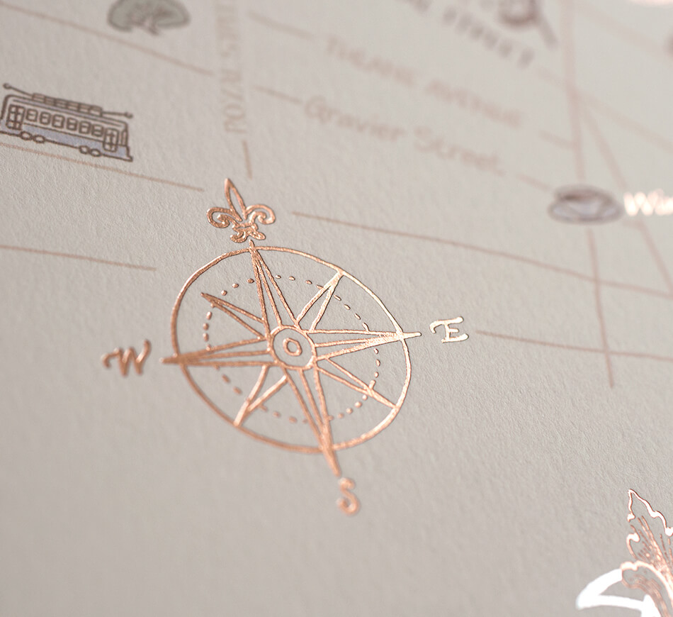 Rose gold compass on map