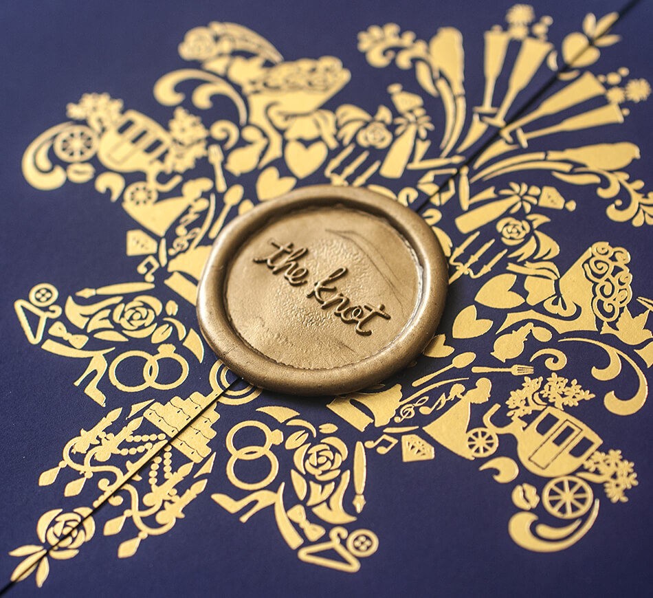 Gold wax seal and gold foil on a purple paper